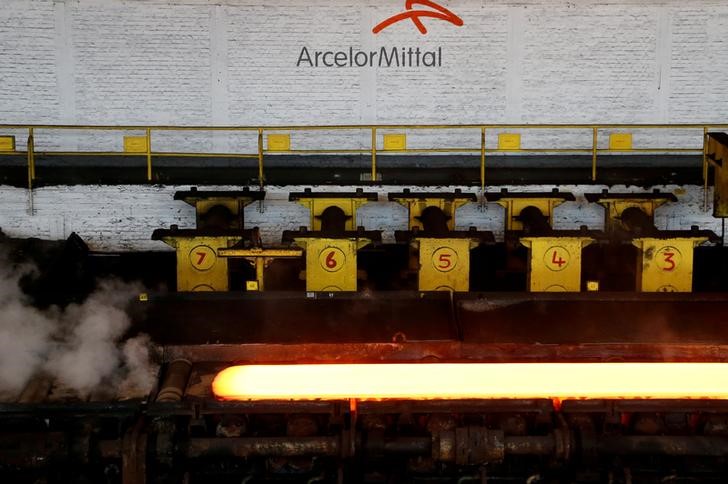 © Reuters. A red-hot steel plate passes through a press at the ArcelorMittal steel plant in Ghent