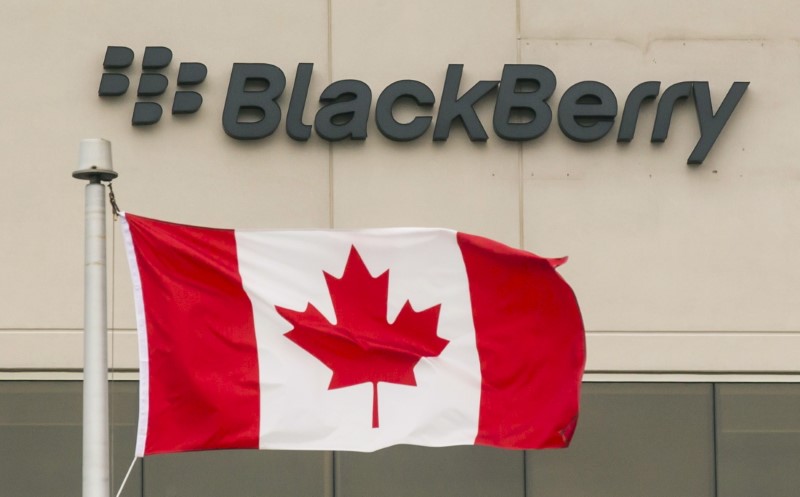 © Reuters. A Blackberry logo hangs behind a Canadian flag at their offices on the day of their annual general meeting for shareholders in Waterloo, Canada