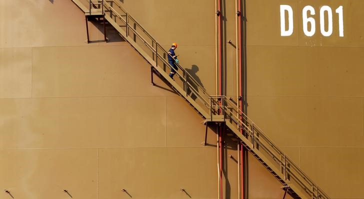 © Reuters. Рабочий спускается по лестнице нефтехранилища в турецком порту Джейхан