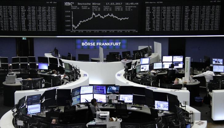 © Reuters. Traders work at their desks in front of the German share price index DAX board in Frankfurt