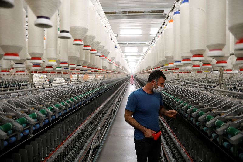 © Reuters. A worker makes a regular check on machines in a textile factory in Diyarbakir