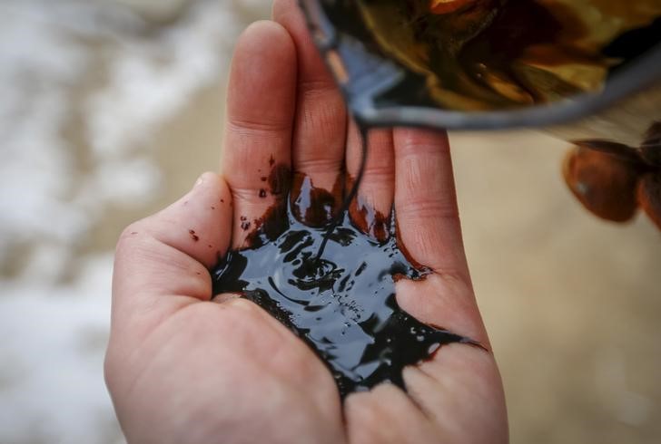 © Reuters. A picture illustration shows oil being poured on a palm at oil field in Kyzylorda region, southern Kazakhstan