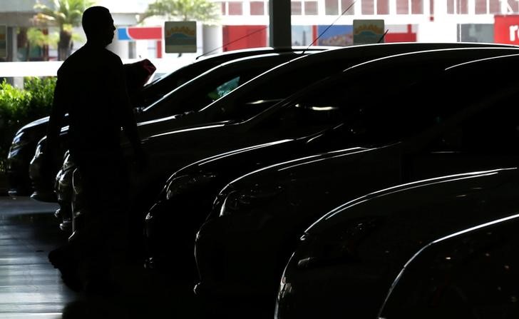 © Reuters. Homem passa por carros em concessionária em São Paulo