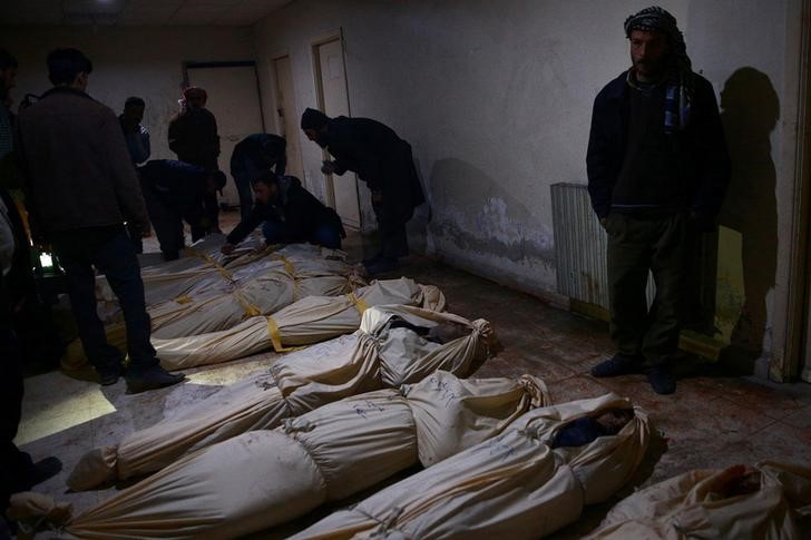 © Reuters. Pessoas tentam identificar corpos após ataque a Douma, perto de Damasco