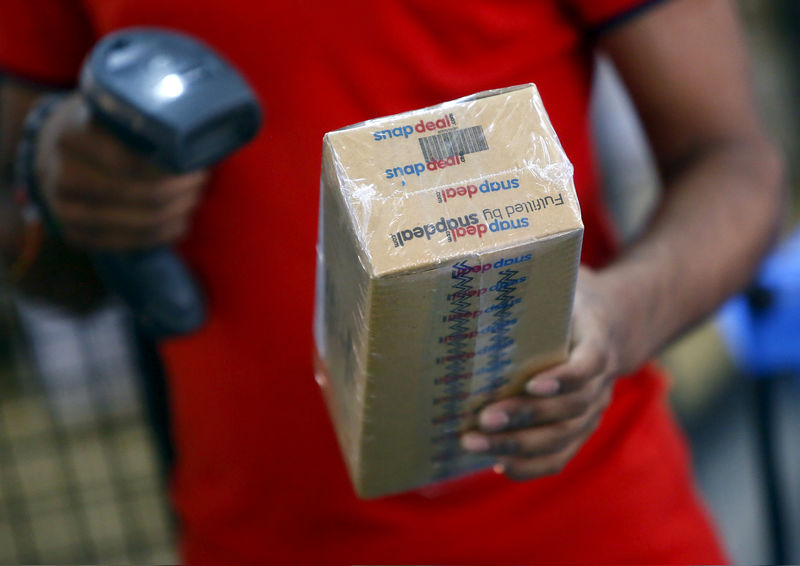 © Reuters. FILE PHOTO: A worker of  Indian e-commerce company Snapdeal.com scans barcode on a box after it was packed at the company's warehouse in New Delhi