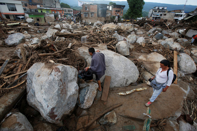 © Reuters. Pessoas em uma rua destruída após inundação e deslizamento de lama em Mocoa, na Colômbia.