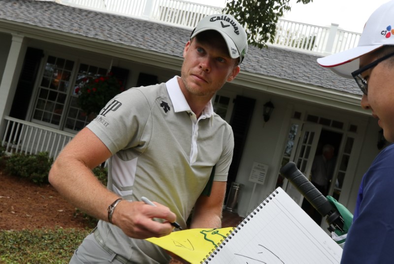 © Reuters. Willett of England signs an autograph during practice rounds for the 2017 Masters at Augusta National Golf Course in Augusta