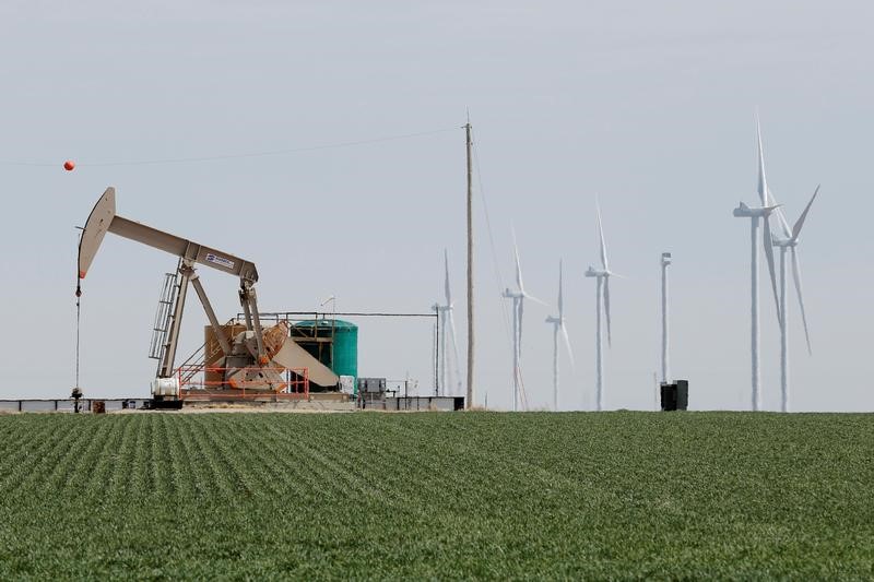 © Reuters. An oil derrick and wind turbines stand above the plains north of Amarillo, Texas