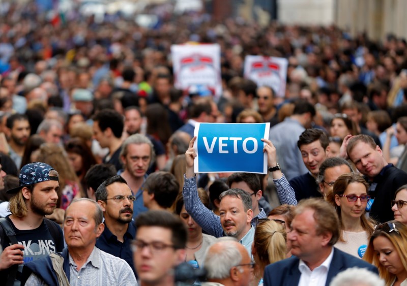 © Reuters. A demonstrator holds up a banner saying "Veto" during a rally against a new law passed by Hungarian parliament which could force the Soros-founded Central European University out of Hungary