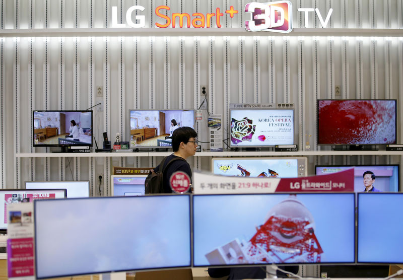 © Reuters. FILE PHOTO: A man looks at LG Electronics' TV sets, which are made with LG Display flat screens, at its store in Seoul