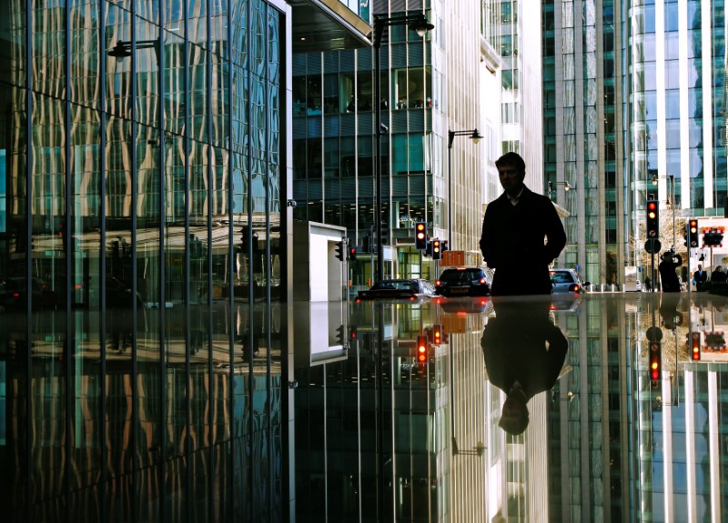 © Reuters. FILE PHOTO: People walk through the the Canary Wharf financial district in London