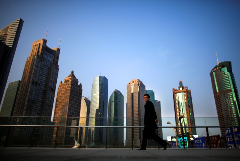 © Reuters. FILE PHOTO: A man walks at the financial district of Pudong in Shanghai