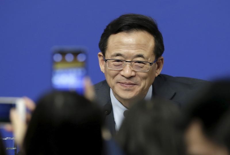 © Reuters. Journalists take photos of Liu Shiyu, chairman of the China Securities Regulatory Commission, as he arrives for a news conference in Beijing