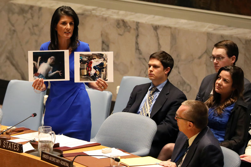 © Reuters. U.S. Ambassador to the United Nations Nikki Haley holds photographs of victims during a meeting at the United Nations Security Council on Syria at the United Nations Headquarters in New York City