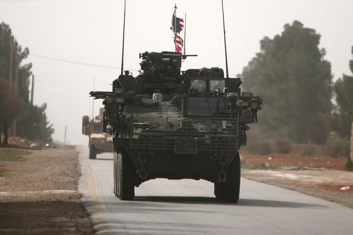 © Reuters. U.S. army vehicles drive north of Manbij city