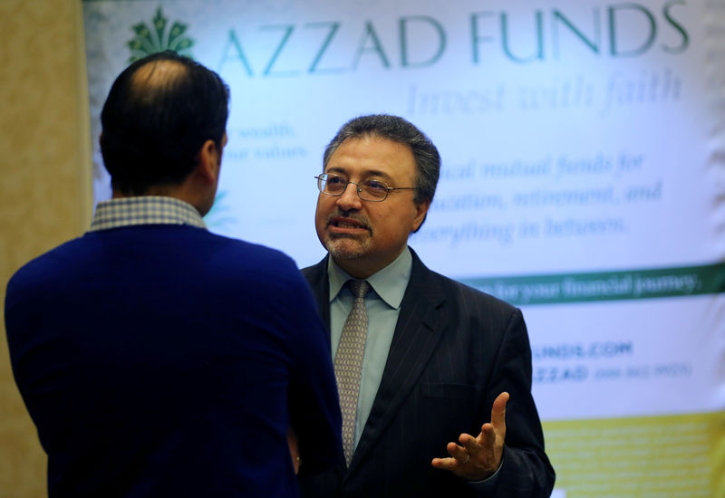 © Reuters. Activist investor Bashar Qasem, President and CEO of Azzad Asset Management Inc, speaks to a client during a conference in Huntington Beach, California