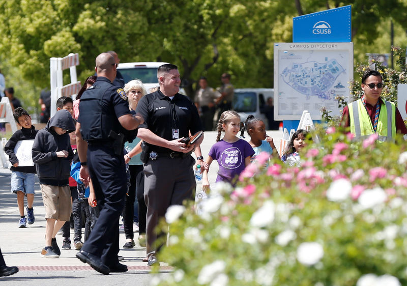 © Reuters. Policiais acompanham estudantes após ataque de tiros em uma escola de ensino fundamental, em San Bernardino, na Califórnia.