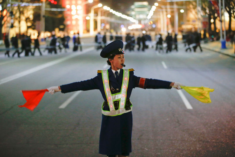 © Reuters. A policewoman controls the traffic as people gather near the main Kim Il Sung square in central Pyongyang