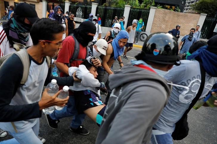 © Reuters. Manifestante ferido é carregado em protesto em Caracas