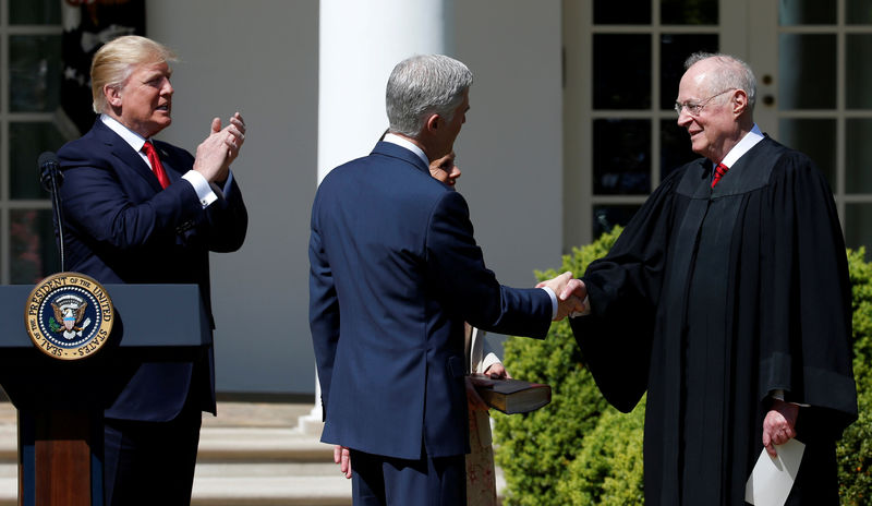 © Reuters. FILE PHOTO: Judge Neil Gorsuch shakes hands with Justice Anthony Kennedy after he was sworn as an Associate Supreme Court as Trump watches in Washington