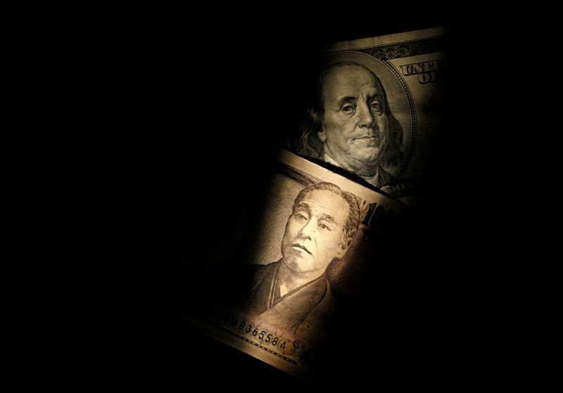 © Reuters. FILE PHOTO: Light is cast on U.S. one-hundred dollar bill next to Japanese 10,000 yen note