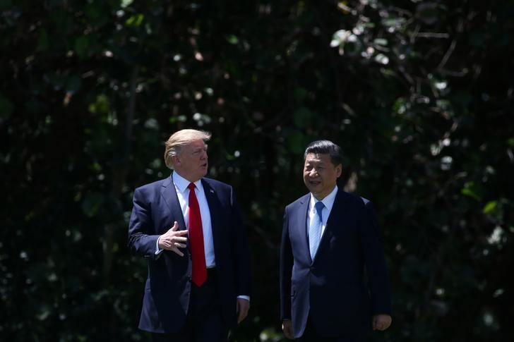 © Reuters. U.S. President Donald Trump and China's President Xi Jinping chat as they walk along the front patio of the Mar-a-Lago estate after a bilateral meeting in Palm Beach