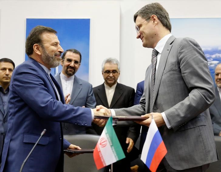 © Reuters. Russian Energy Minister Novak and Iranian Communications Minister Vaezi exchange documents during signing ceremony after their meeting in Moscow
