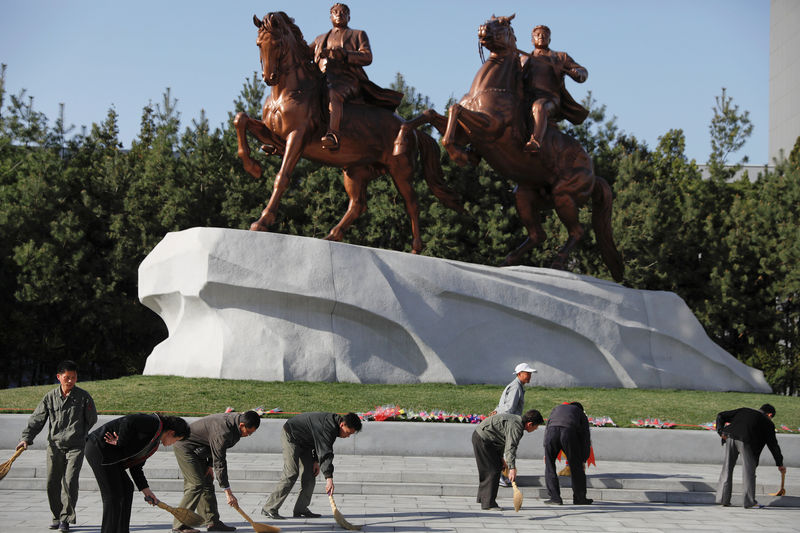 © Reuters. People sweep in front of statues of former North Korean leaders Kim Il Sung and Kim Jong Il in central Pyongyang