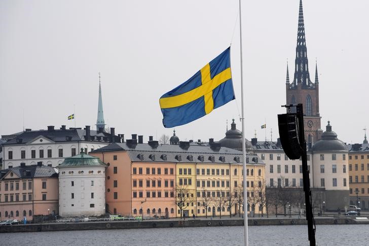 © Reuters. Flag at half mast at the official ceremony at Stockholm City Hall with one minute of silence at noon to remember the victims of Friday's terror attack on Drottninggatan