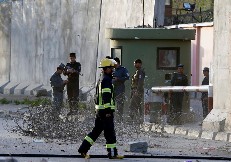 © Reuters. Afghan policemen keep watch at the site of a suicide bomb attack in Kabul