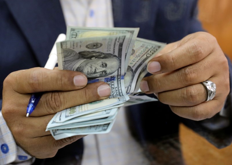 © Reuters. FILE PHOTO: A man counts U.S dollar bills at a money exchange office in central Cairo