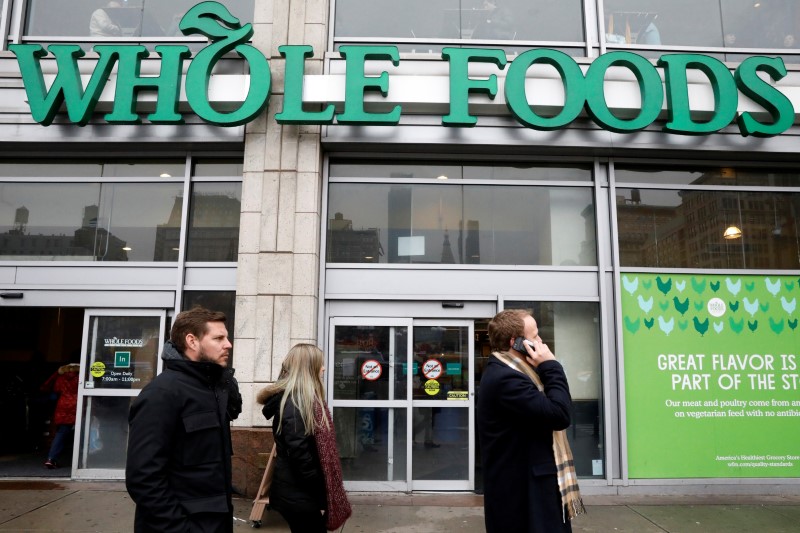 © Reuters. People pass by a Whole Foods Market in New York