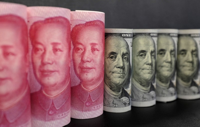 © Reuters. FILE PHOTO: U.S. 100 dollar banknotes and Chinese 100 yuan banknotes are seen in this picture illustration in Beijing