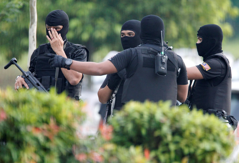 © Reuters. Armed policemen stand guard before the arrival of suspects charged with the murder of Kim Jong Nam, at a Sepang court