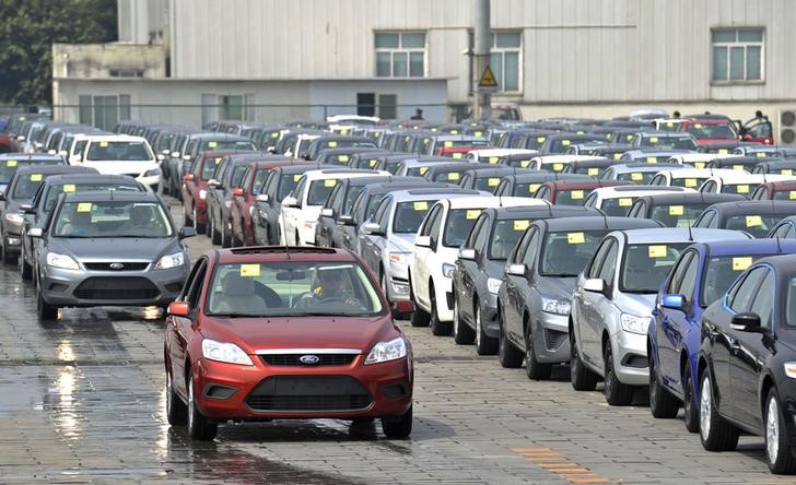 © Reuters. FILE PHOTO - Employees drive newly assembled Ford cars into the parking lot of a Ford manufacturing plant in Chongqing municipality