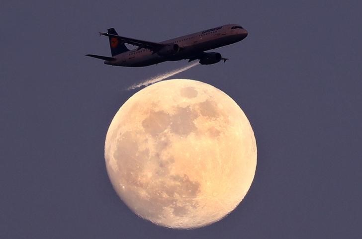 © Reuters. An airplane of German air carrier Lufthansa passes the moon over Frankfurt