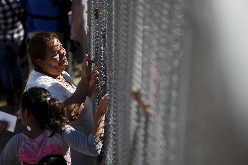 © Reuters. FILE PHOTO: A woman touches a family member through the border fence between Ciudad Juarez and El Paso, United States, after a bi-national Mass in support of migrants in Ciudad Juarez