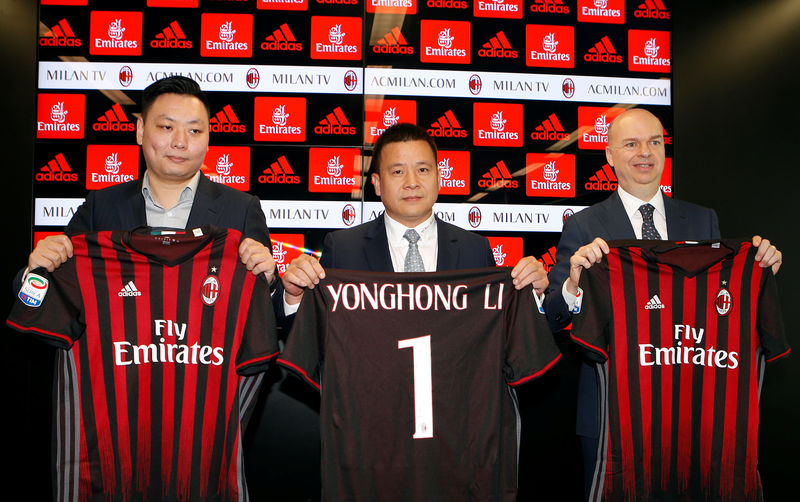 © Reuters. David Han Li, Yonghong Li and Fassone show a AC Milan jersey during a news conference in Milan