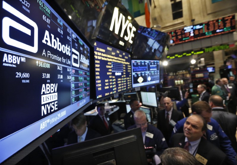 © Reuters. Traders gather at the booth that trades Abbott Laboratories on the floor of the New York Stock Exchange