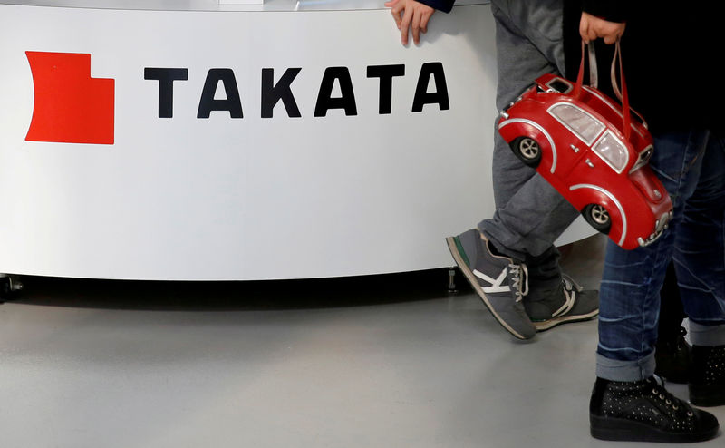 © Reuters. FILE PHOTO: Visitors walk past a logo of Takata Corp on its display at a showroom for vehicles in Tokyo, Japan