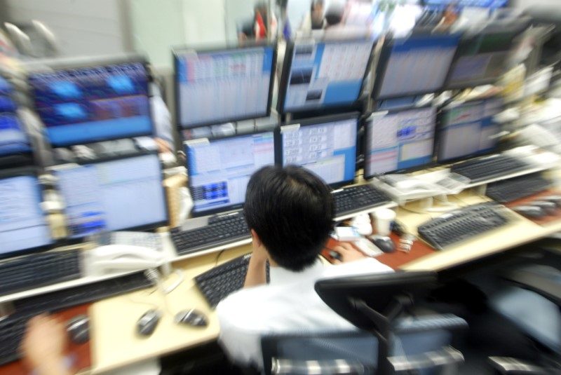 © Reuters. MONEY DEALER WORKS IN FRONT OF MONITORS AT DEALING ROOM IN TOKYO.