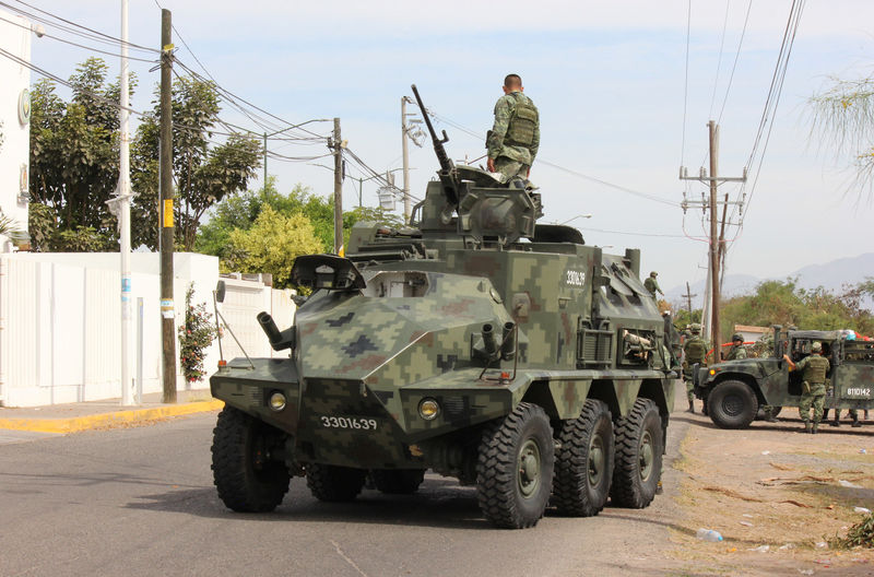 © Reuters. A soldier atop a vehicle is seen outside the Forensic Medical Service (SEMEFO) after the arrival of the body of Francisco Zazueta, also known as "Pancho Chimal," in Culiacan