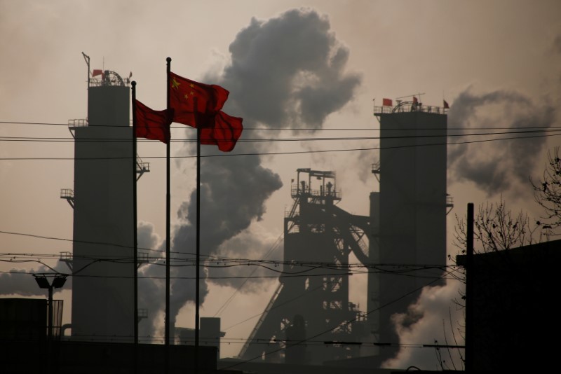 © Reuters. Bandeiras nacionais da China ao lado de uma fábrica de aço em Wu'an