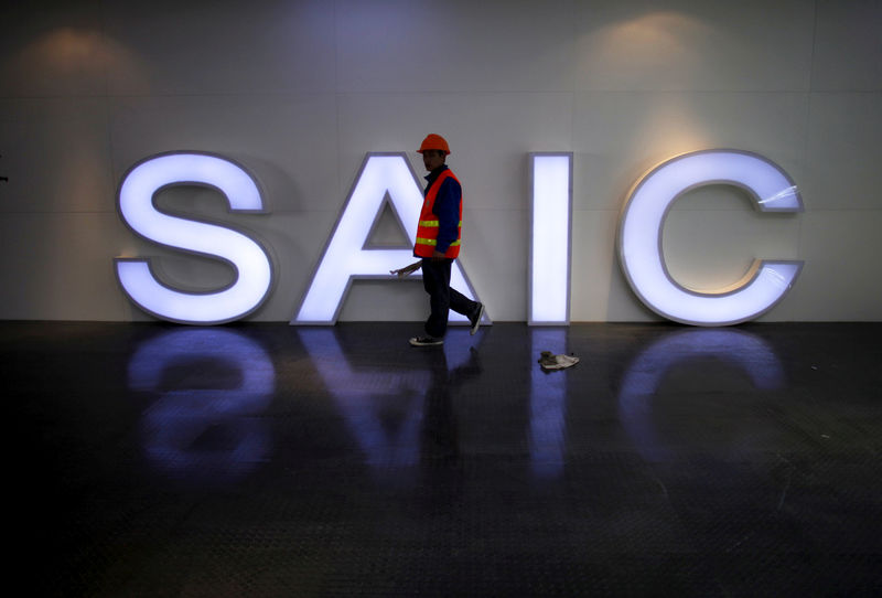 © Reuters. FILE PHOTO:  A worker walks past a lighted signage of the SAIC before the opening of the Shanghai International Automobile Industry Exhibition in Shanghai