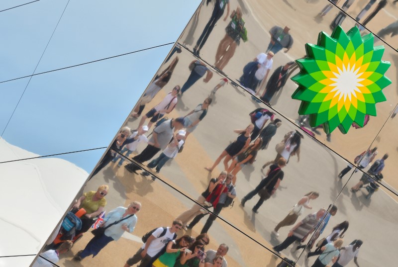 © Reuters. Spectators are seen reflected in a British Petroleum sponsors building in Olympic Park at the London 2012 Paralympic Games