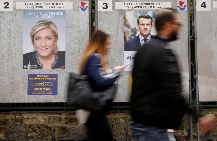 © Reuters. Cartazes de Marine Le Pen e Emmanuel Macron em Paris