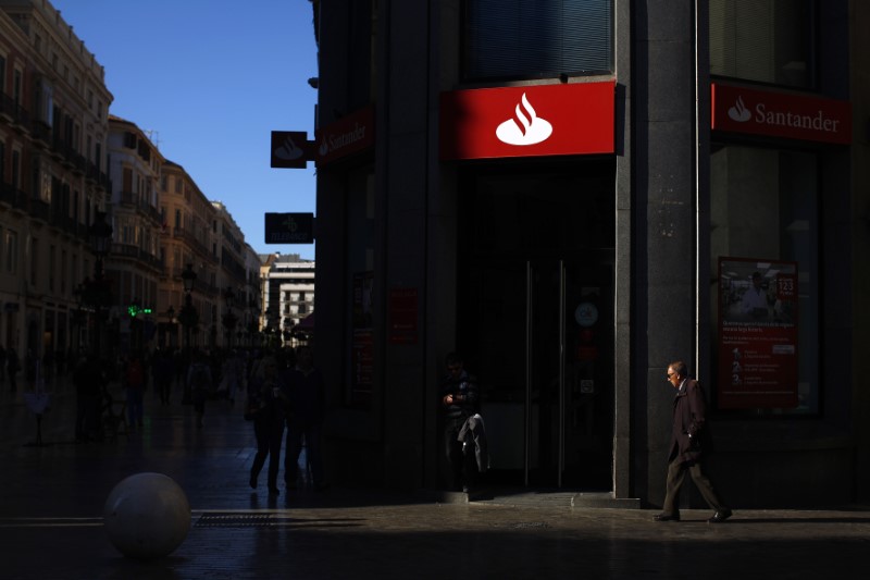 © Reuters. People walk past a Santander bank in downtown Malaga
