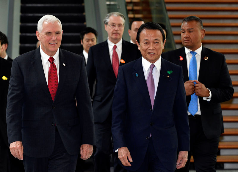 © Reuters. US VP Pence and Japan's Deputy PM Aso walk on their way to a meeting in Tokyo