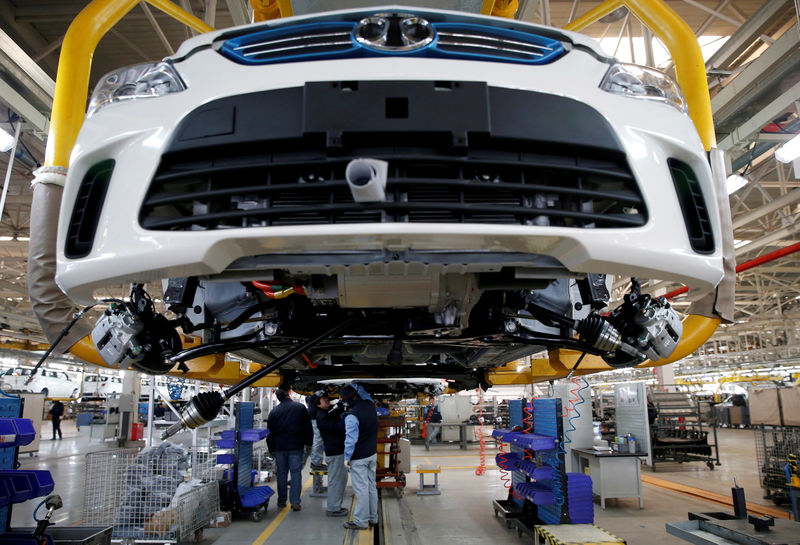 © Reuters. FILE PHOTO: Employees work on an assembly line producing electronic cars at a factory of Beijing Electric Vehicle, funded by BAIC Group, in Beijing