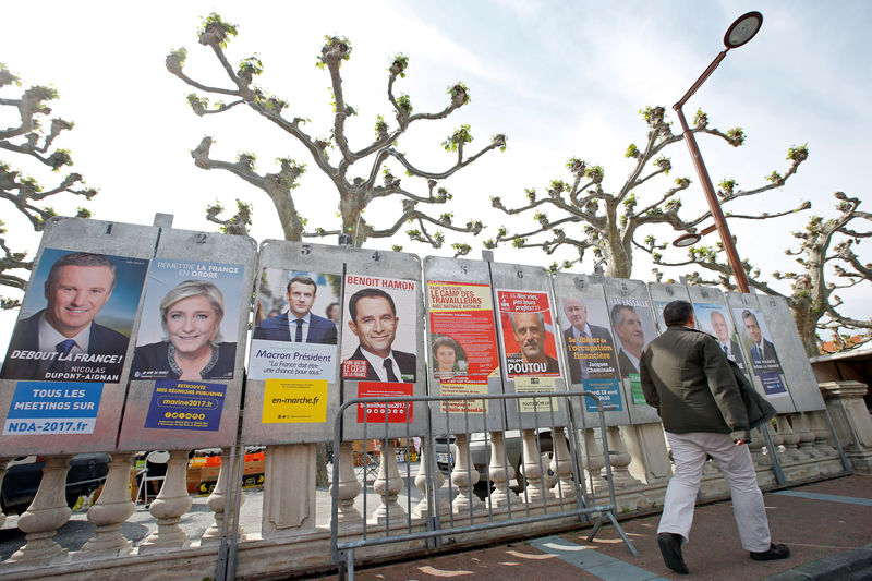 © Reuters. Homem passa por cartazes de campanha dos candidados à Presidência da França